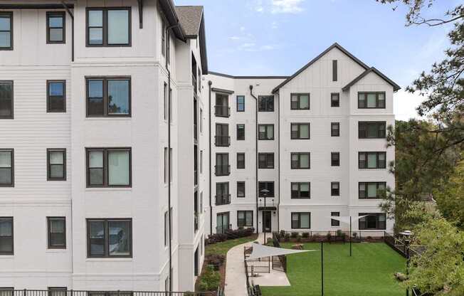 A white building with a green lawn in front.