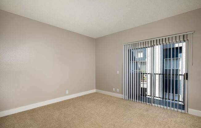 Empty room with a window and a view of a balcony.