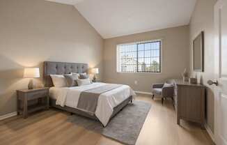 A bedroom with a large bed and a window.