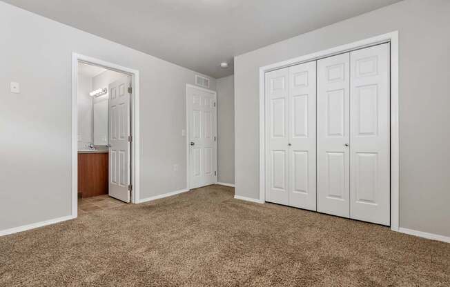 A room with white walls and brown carpet.