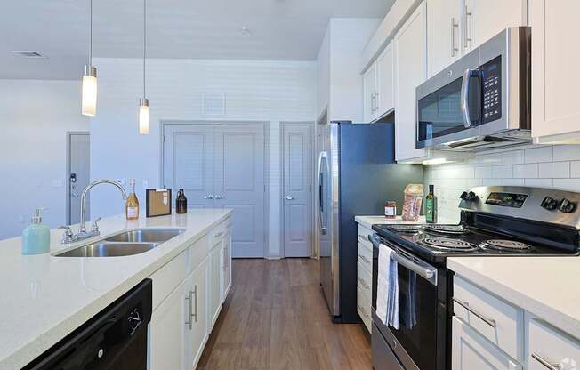 A kitchen with black appliances and white cabinets.