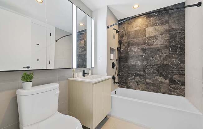 a bathroom with a white toilet and a shower and a sink at The Paxton, Brooklyn