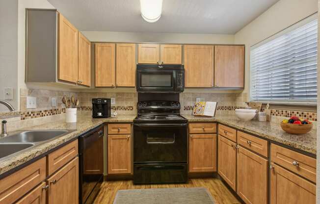 a kitchen with black appliances and wooden cabinets