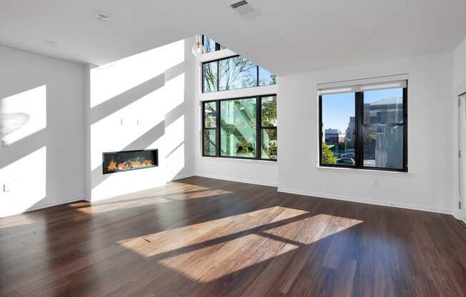 a living room with white walls and wood floors and a fireplace