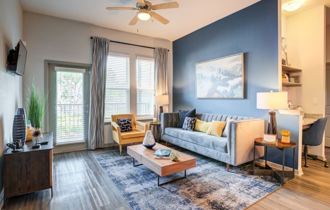 an open living room with blue walls and a ceiling fan