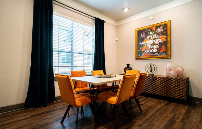 a dining room with a table and chairs and a painting on the wall