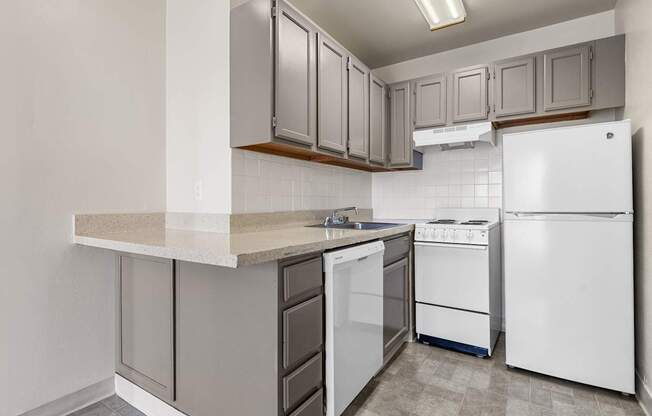 A kitchen with white appliances and grey cabinets.