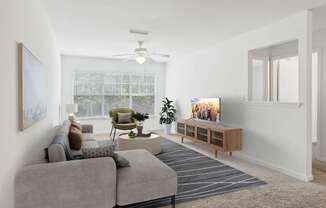 A living room with a grey sofa, a green armchair, a coffee table, and a television.