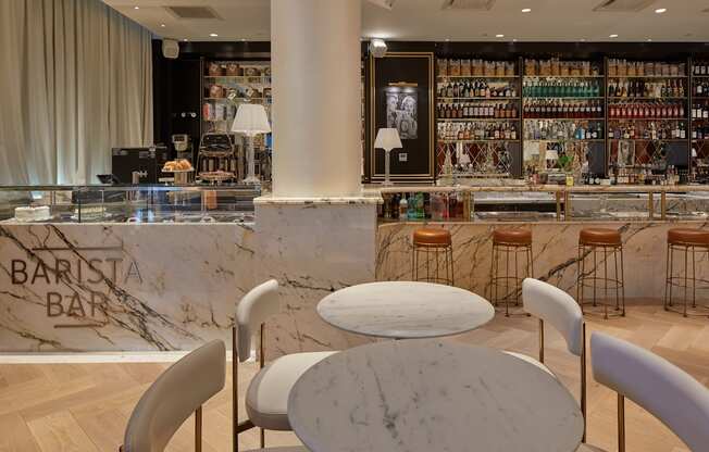 A barista bar with a marble counter and bar stools.