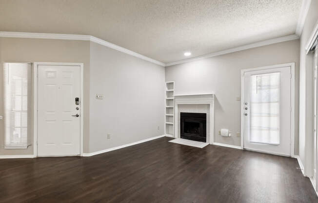 A spacious living room with a fireplace and hardwood floors.