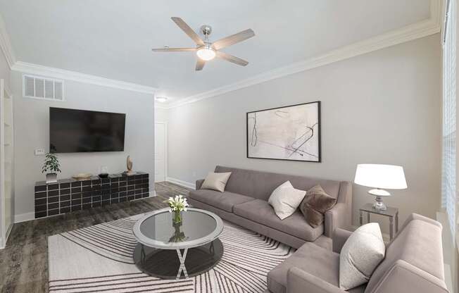 a living room with a couch and a table and a ceiling fan