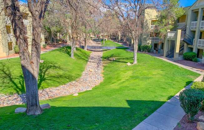 a path through the grass between two apartment buildings