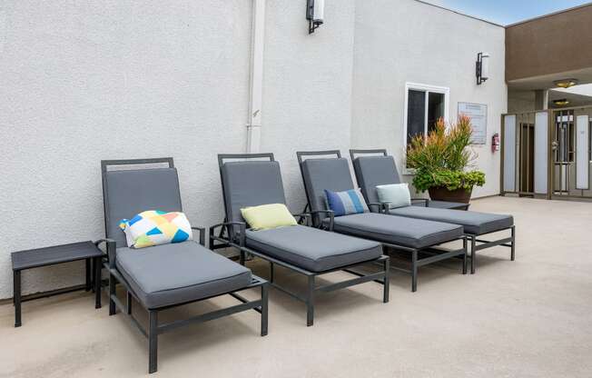 a row of chairs outside of a building with pillows