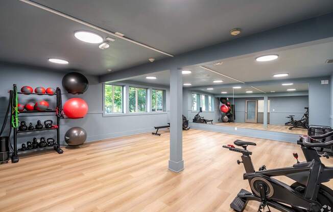 A gym with a variety of exercise equipment and a mirror on the wall.