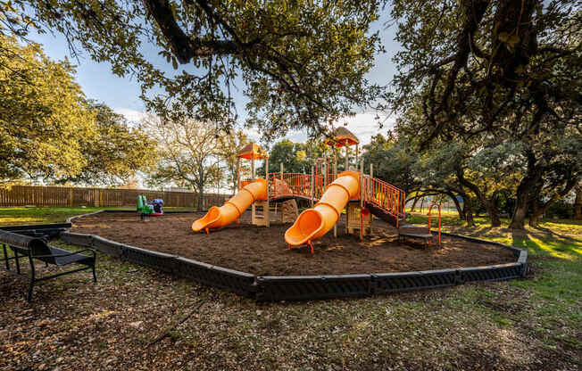 A playground with a slide and a green lawn.