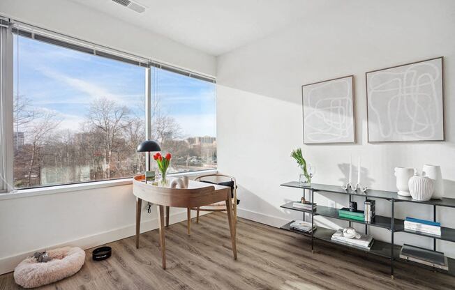 a living room with a large window and a desk at Sinclaire on Seminary, Alexandria 