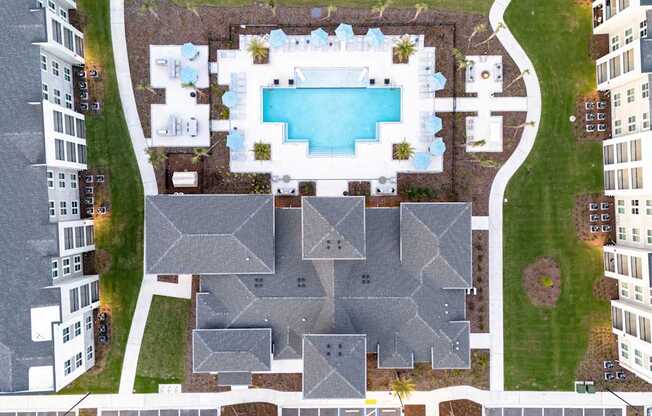 A bird's eye view of a residential area with a swimming pool.