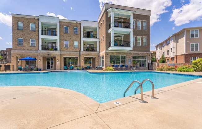 a swimming pool with an apartment building in the background