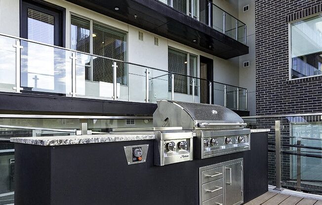 A modern outdoor kitchen with a grill and sink.