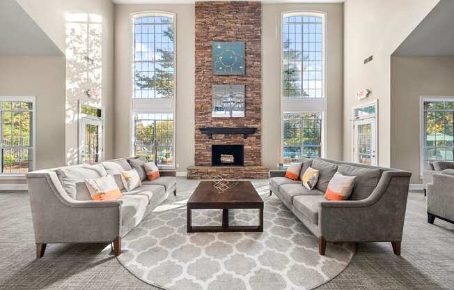 a living room with couches and a table in front of a fireplace