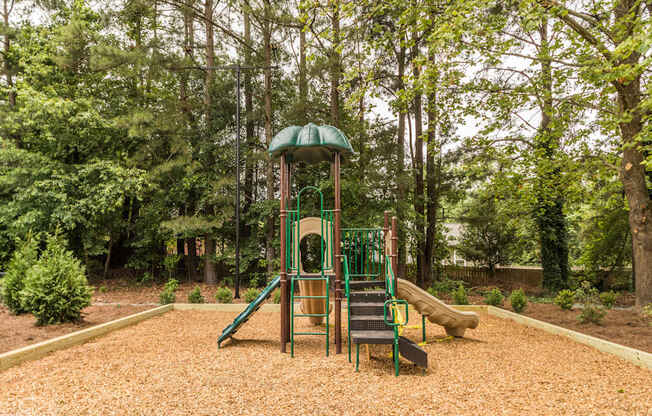 A playground with a green slide and a yellow slide.