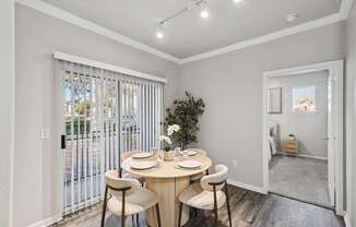 A dining room with a round table and chairs.