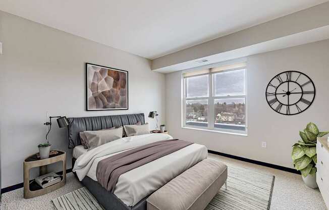 A bedroom with a large bed and a window overlooking a snowy landscape.