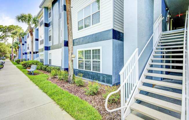 Apartment Building Exterior and Stairway Next to Grass and Decorative Plants