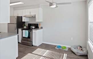 A kitchen with a black stove top oven and white cabinets.