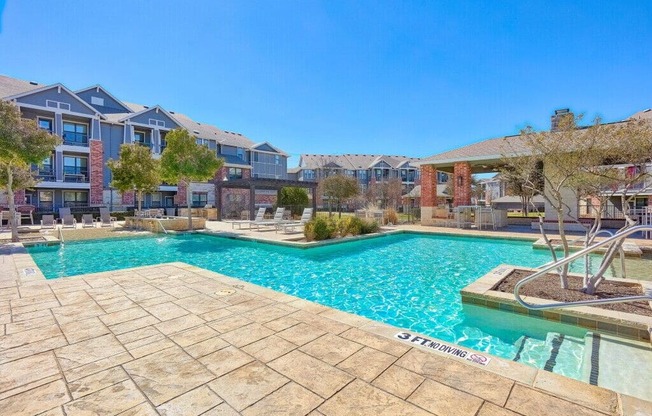 a swimming pool with an apartment building in the background at Platinum Castle Hills, Lewisville, Texas