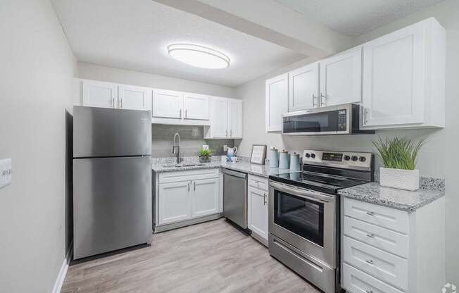 A modern kitchen with stainless steel appliances and white cabinets.