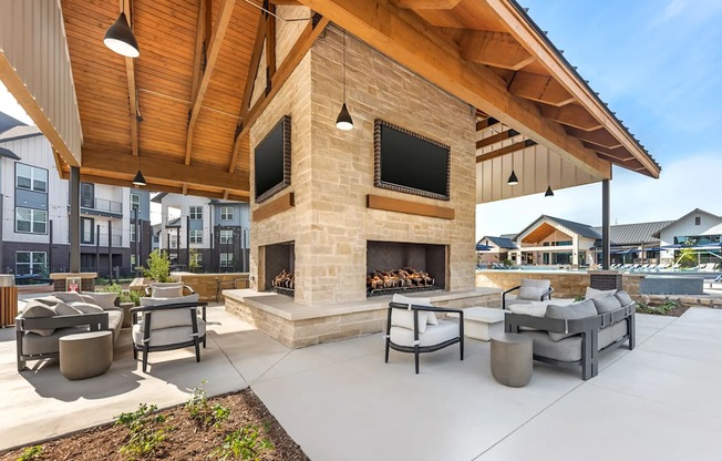 A patio with a fireplace and seating area.