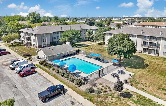 A swimming pool surrounded by apartment buildings and cars.
