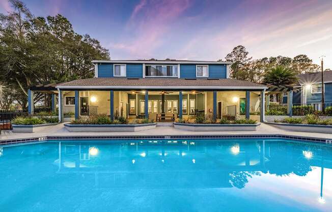 A blue house with a pool in front.