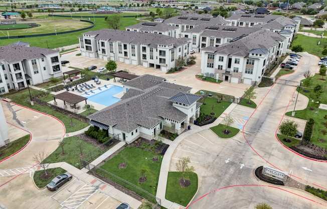 an aerial view of a group of houses and a swimming pool