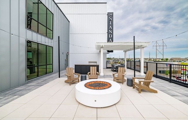 a patio with a fire pit and chairs and a building at The Standard on 32nd, West Fargo, North Dakota