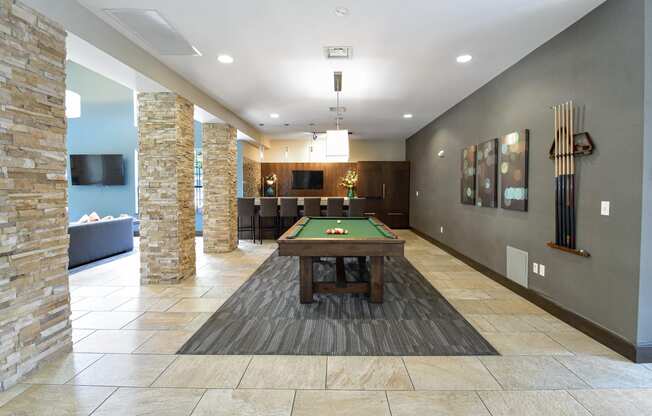 a pool table in the clubhouse at the enclave at woodbridge apartments in sugar land, tx