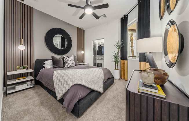 A bedroom with a large bed and a ceiling fan.