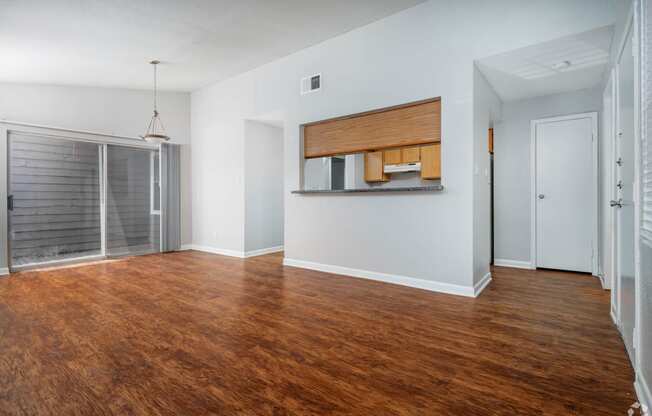 an empty living room with wood flooring and a glass closet