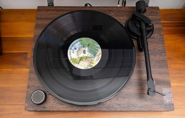 a record on a wooden table with a record player and a vinyl record on it