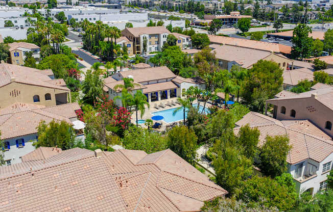 A bird's eye view of a residential area with houses and a pool.