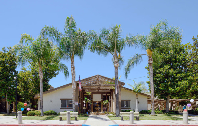 a building with palm trees in front of it at Oak Terrace Senior Apts, Hemet, CA 92543   