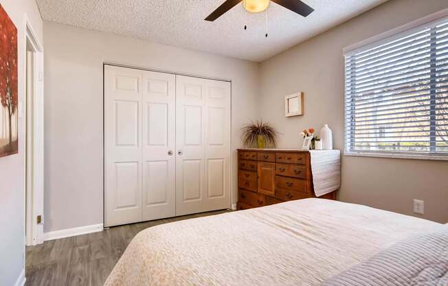 A bedroom with a bed, dresser, and a ceiling fan at Mountain Vista Apartments, Lakewood, Colorado
