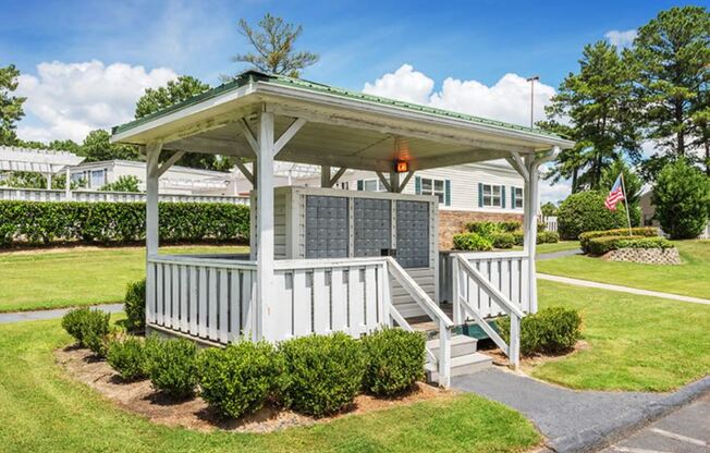 a white gazebo with a porch in a yard