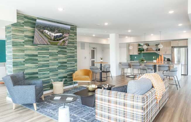 A living room with a plaid couch and a green wallpapered wall.