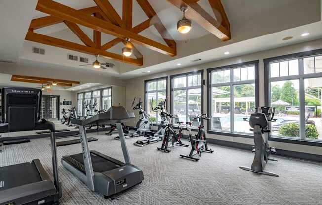 A gym with treadmills, elliptical machines, and a television.