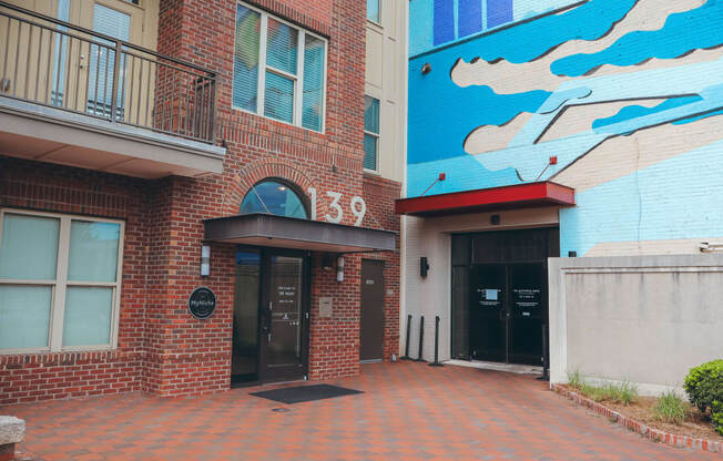 the entrance to a building with a mural on the side