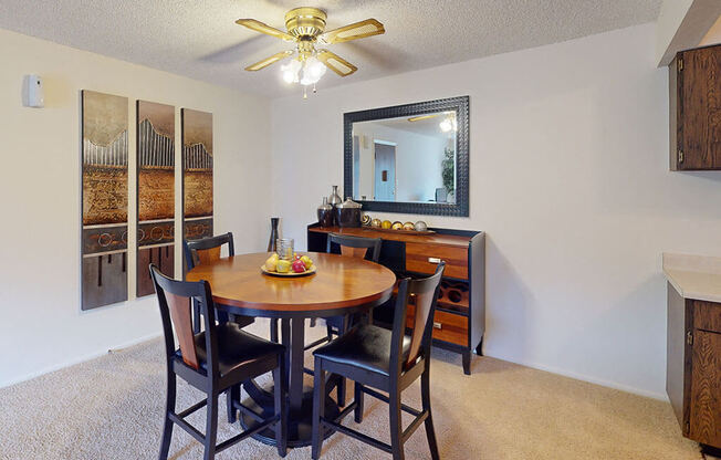 a dining room with a table and chairs and a ceiling fan