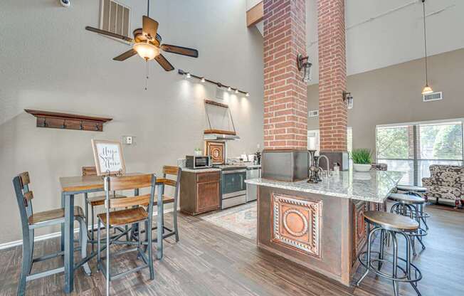 A kitchen with a bar and chairs.
