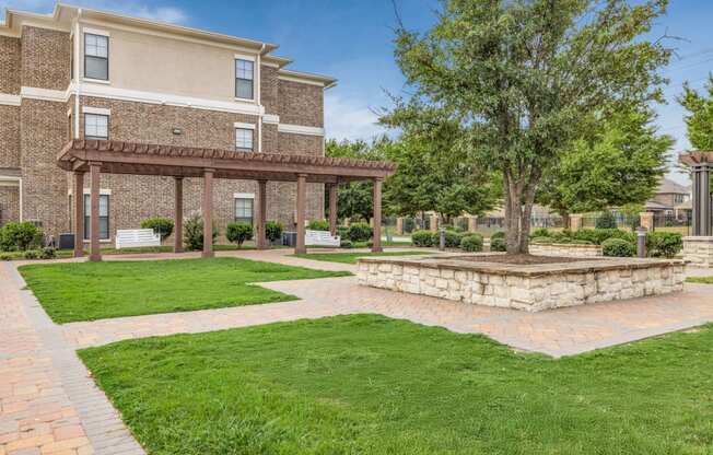 a brick patio with a stone fire pit in front of a building